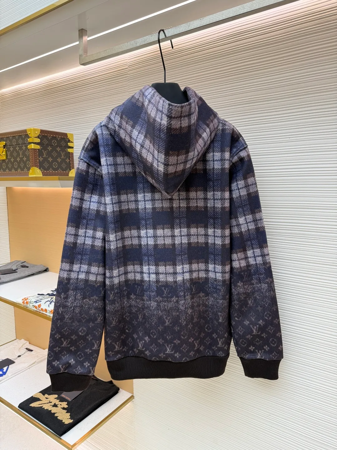 LOUIS VUITTON plaid gradient long-sleeved hoodie ●Original version: Purchased and developed for 15100 ●Item number: 1681896-B40 ●Fabric: wool blended fabric ●Technology: Digital direct printing ●Color: Purple ●Version: Fitted version ●Weight: about 1035 grams ●Size: S-M-L-XL ●Description: This hooded sweatshirt uses splicing technology to create a layered texture: the upper part is made of wool blended fabric with a blue and gray plaid pattern, and is pre-shrunk to ensure a stable fit; the lower part and sleeves use digital printing technology to present a gradient Monogram dark pattern, and the ink penetrates the fiber to achieve high color fastness. The hood has a built-in invisible lining to enhance stiffness, and the drawstring is made of wear-resistant nylon rope with a metal bell for smooth pulling. The front kangaroo pocket is made of welted bag technology, and the edge of the bag mouth is reinforced with double stitching. The cuffs and hem are made of ribbed knitted fabric, and the elastic hemming fits the body shape. The seams throughout the garment are high-strength stitches of the same color. Precision sewing every 3cm/12 stitches improves durability. The overall craftsmanship takes into account both visual details and practical durability. The overall wiring is straight and delicate, the fabric is comfortable and soft, and the color is consistent without color difference. It can be matched with the same style to create a fashionable look and control various occasions. Customized accessories, complete with three standards, same style for men and women!